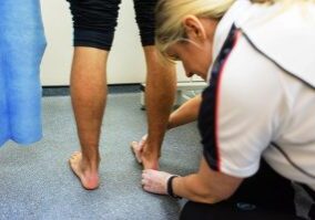 Judith Cowling examining a patient's feet at Foot Talk Podiatry