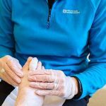 A podiatrist treating a patient with corns